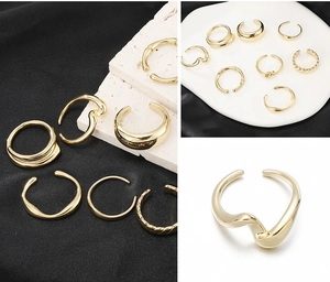 Macro shot of gold plated wave and braided pattern rings on white ceramic plate