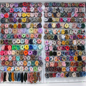 Detailed display of assorted velvet tie-dye scrunchies in various vibrant colors and patterns