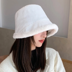 Detail shot of white plush bucket hat with thick faux fur trim for winter warmth