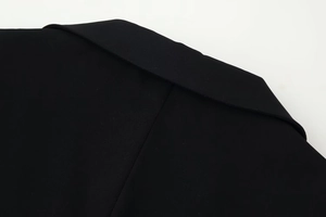 Macro shot of notch lapel detail and premium twill fabric texture on black jacket