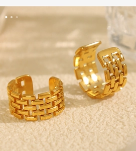 Macro view of gold titanium steel rings with intricate woven chain texture on beige background