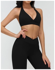 Dettaglio dei leggings neri da yoga a vita alta con fascia a V e reggiseno sportivo