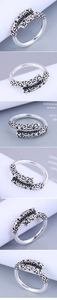 Dettaglio macro di anello regolabile vintage in argento con intricati motivi a nuvola