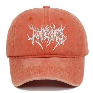 Detailed close-up of Gothic white embroidery on a washed red cotton baseball cap