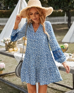 Detailed close-up of delicate lace splicing on the cuffs of a blue floral summer dress