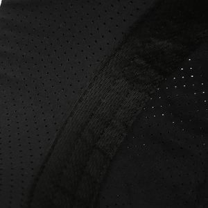 Macro shot of breathable honeycomb mesh fabric and reinforced knit strap on a black sports cap