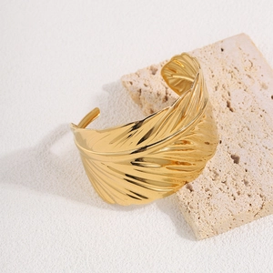 Detailed macro view of golden leaf cuff bracelet with intricate vein texture and polish
