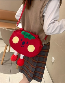 Detailed view of a cute plush strawberry crossbody bag with adjustable shoulder strap