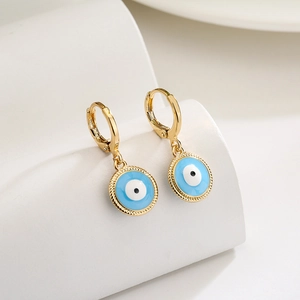 Gold-plated geometric evil eye earrings with blue enamel and zircon inlay on white props