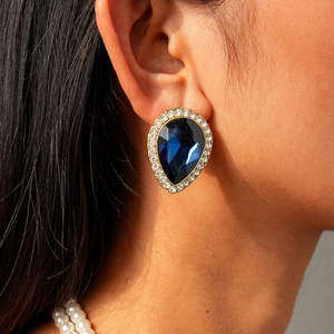 Vue macro des boucles d'oreilles vintage avec cristal bleu et placage à l'or