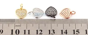 Macro shot showing four mini heart charms next to a ruler for 11mm size detail