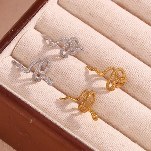 Macro view of gold and silver snake ear cuffs with fine scale textures in a jewelry box