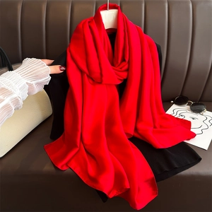 Detail of red satin scarf with silky texture and smooth drape in a fashion setting