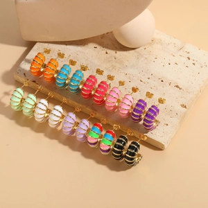 Detail of colorful enamel C-shape hoop earrings set in ten vibrant shades with gold plating