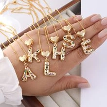 Macro shot of gold-plated heart clasp letter pendants with colorful cubic zirconia