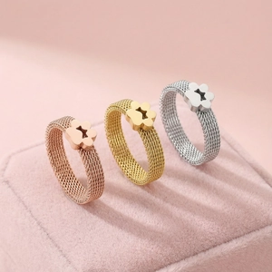 Detailed view of three mesh rings with cat paw prints in rose gold, gold, and silver