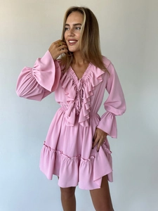 Close-up of pink V-neck chiffon dress detailing ruffle edges and delicate waist ties