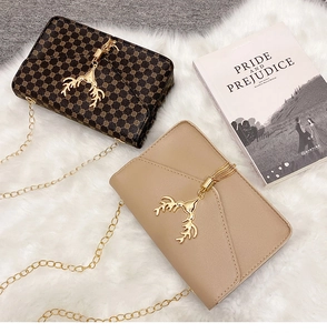 Detail of vintage crossbody bags with gold deer head buckles and metal chain straps