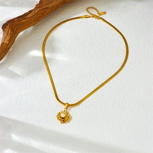 Golden stainless steel snake chain necklace with floral pearl pendant on white background