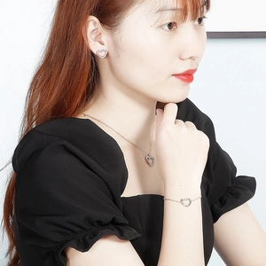 Minimalist silver heart jewelry set with necklace earrings and bracelet on a model