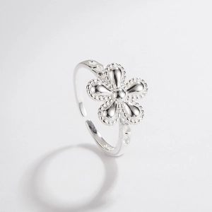 Detailed close-up of a silver flower-shaped adjustable ring with delicate beaded edges