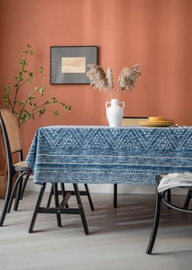 Detailed blue tablecloth featuring white geometric triangle patterns in a boho dining setting