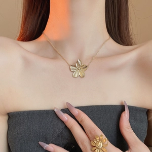 Retro golden flower necklace and daisy ring set with textured petals on female model