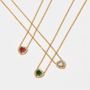 Collier pendentif coeur doré avec zircons rouges, verts et clairs sur fond blanc pur