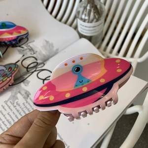 Pink acrylic UFO hair claw clip with colorful alien patterns for space-themed hair styling