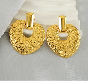 Détail macro de boucles d'oreilles cœur en plaqué or 18K avec une texture martelée unique