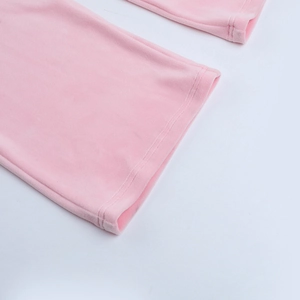 Dettaglio della trama del velluto rosa con doppie cuciture precise sull'orlo dei pantaloni