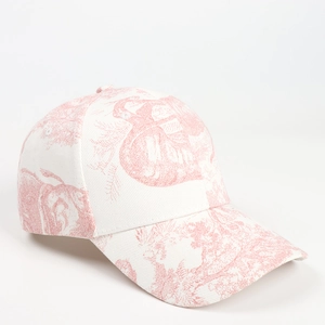 Detailed view of the red Toile de Jouy floral print on a white cotton baseball cap