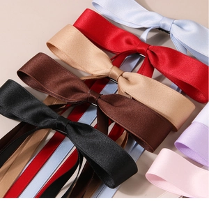 Macro detail of satin ribbon bow hair clips in various elegant pastel colors