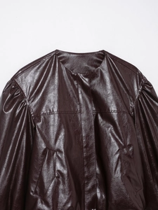 Detailed close-up of dark burgundy faux leather bomber jacket neckline and shoulder seams