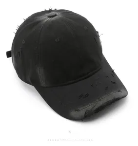 Detailed top view of a washed black cotton baseball cap with vintage distressed edges