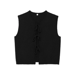 Detail of black V-neck knitted vest featuring a thick cable knit texture and front ties