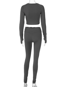 Rear view of tight dark gray yoga set with long sleeve crop top and high waist leggings
