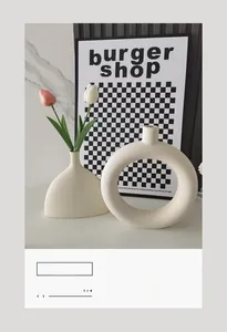 Détails de vases modernes en céramique blanche mate avec décoration de tulipes roses