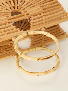 Detailed view of natural bamboo texture and beaded joints on a semicircular handbag