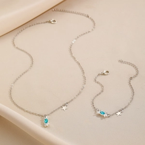 Detalle de conjunto de collar y pendientes de cangrejo plateado con piedras azules
