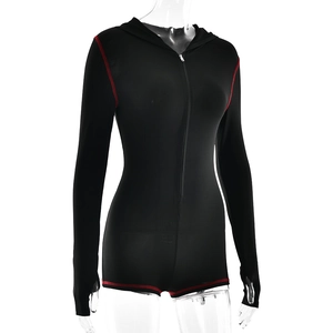 Detail eines schwarzen Kapuzen-Bodysuits mit roten Nähten und Reißverschluss vorne