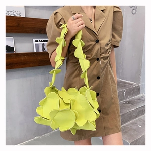 Detail of light green petal-shaped PU leather handbag shown on a shoulder strap