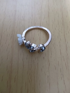 Detailed macro shot of rose gold branch ring with white flowers and small blue gems