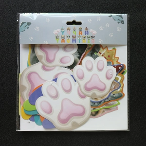 Macro view of cat-themed party decorations with paper paw and crown cutouts in packaging