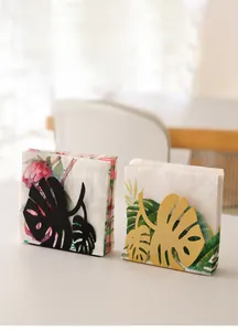 Vertical iron tissue rack featuring a tropical monstera leaf design in gold and black