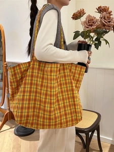 Large checkered canvas tote bag with warm orange plaid pattern for daily shoulder wear