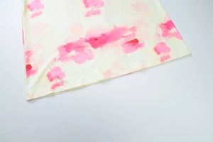 Détail de l'imprimé floral abstrait rose sur le tissu en maille jaune de l'ensemble