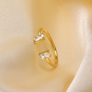 Close-up of golden adjustable ring with rectangle zircons on champagne silk