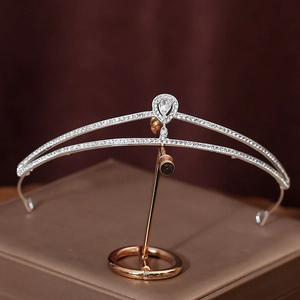 Silver bridal crown with sparkling rhinestones and drop-shaped main stone on a dark background