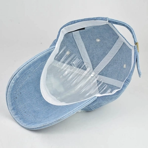 Interior view of light blue denim baseball cap showing sweatband and adjustable metal buckle